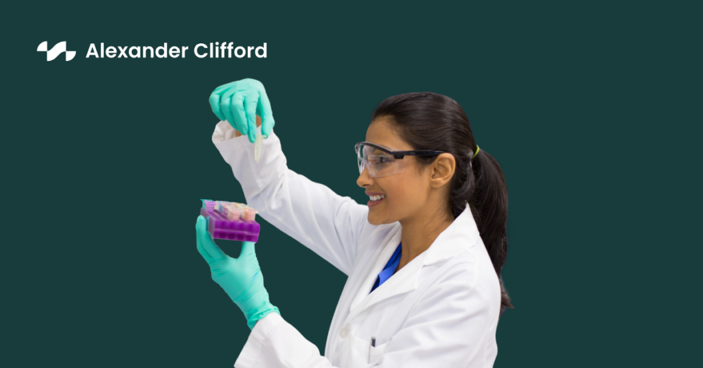 Lab technician in white scrubs analysing results of the contents of a test tube