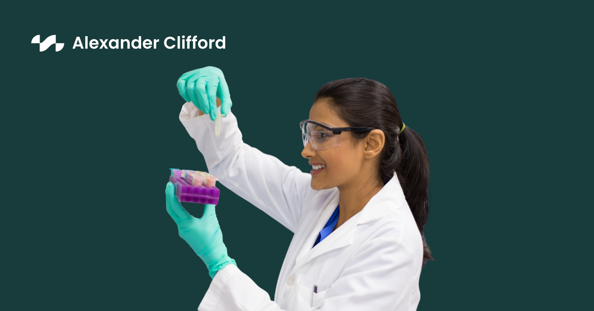 Lab technician in white scrubs analysing results of the contents of a test tube